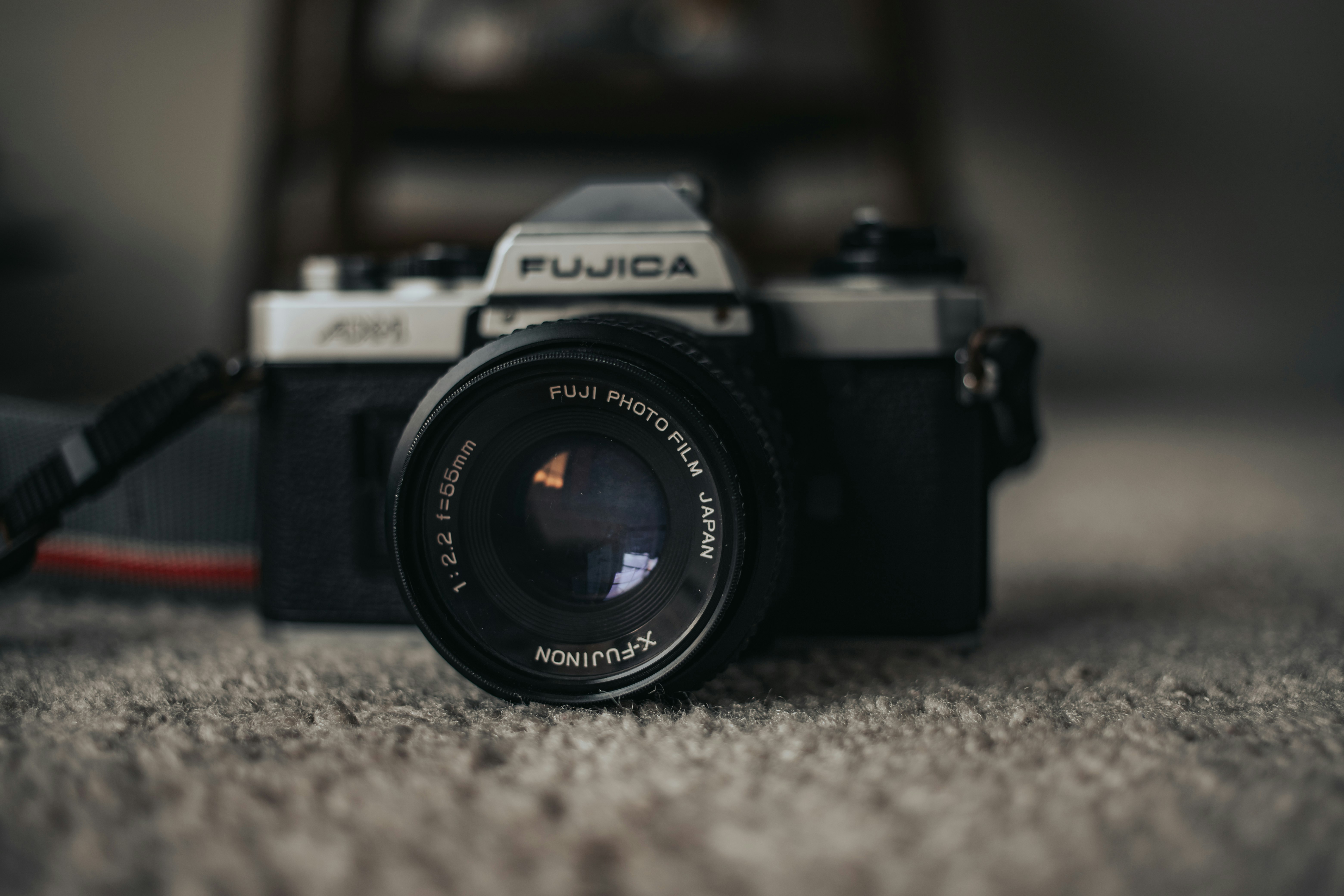 black and silver nikon dslr camera on gray textile